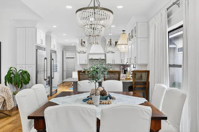a view of a dining room with furniture a chandelier and wooden floor