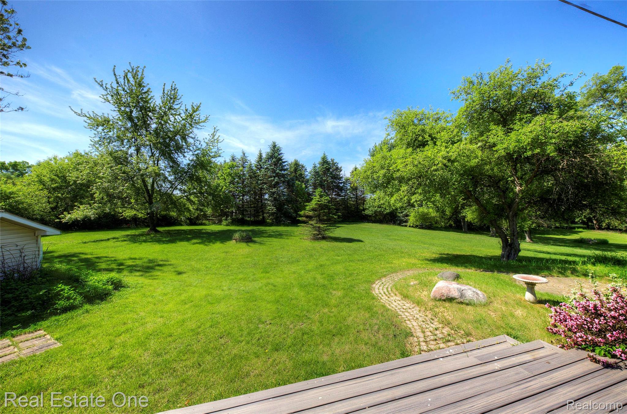 3125 West Commerce Road Milford, MI 48380 - Photo 57 of 63 Expansive green lawn with mature trees and a curving paver pathway