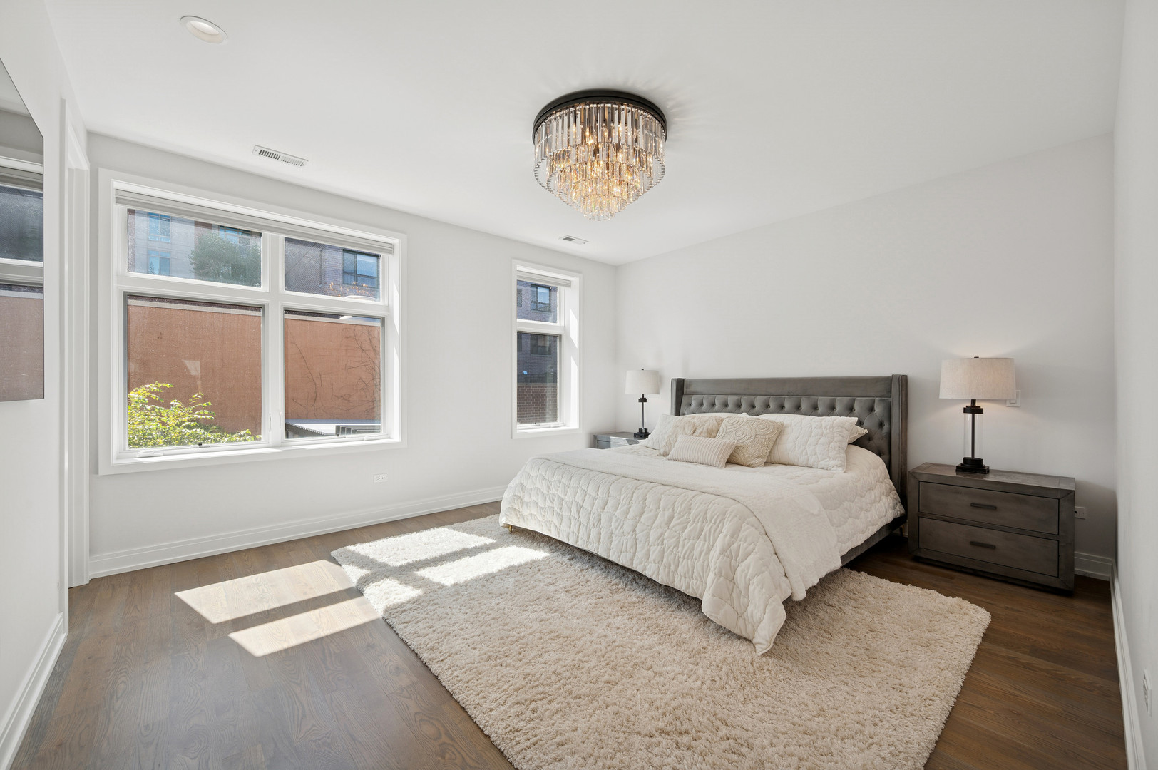 231 West Scott Street, Unit 2 Chicago, IL 60610 - Photo 15 of 33 a bedroom with a large bed and a chandelier