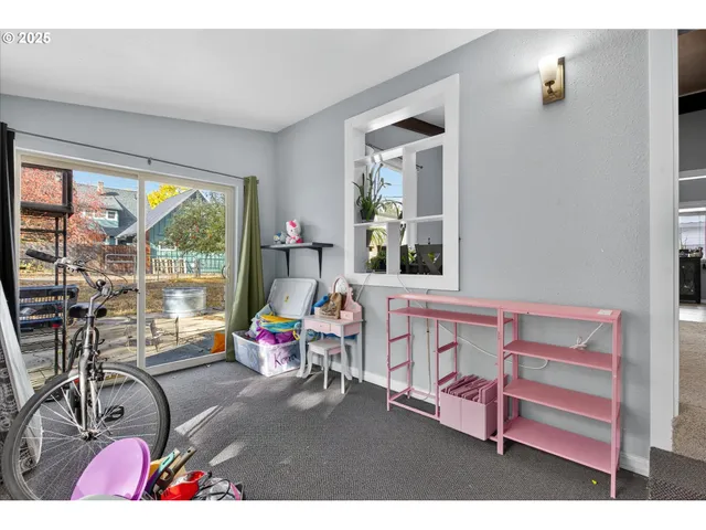 a kitchen with a wooden floor and a view of living room