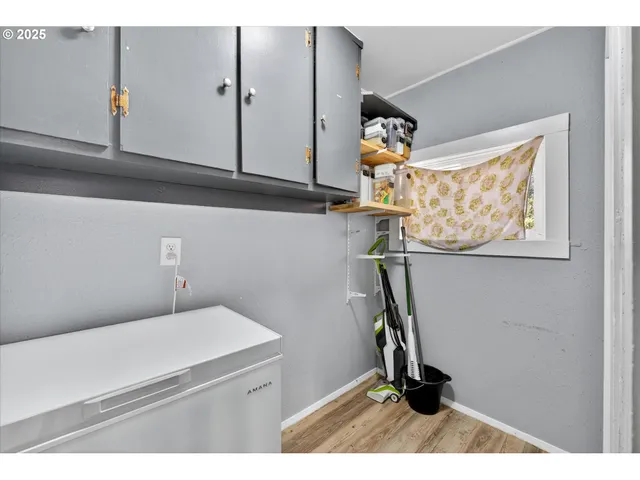 a view of a hallway with wooden floor and a potted plant