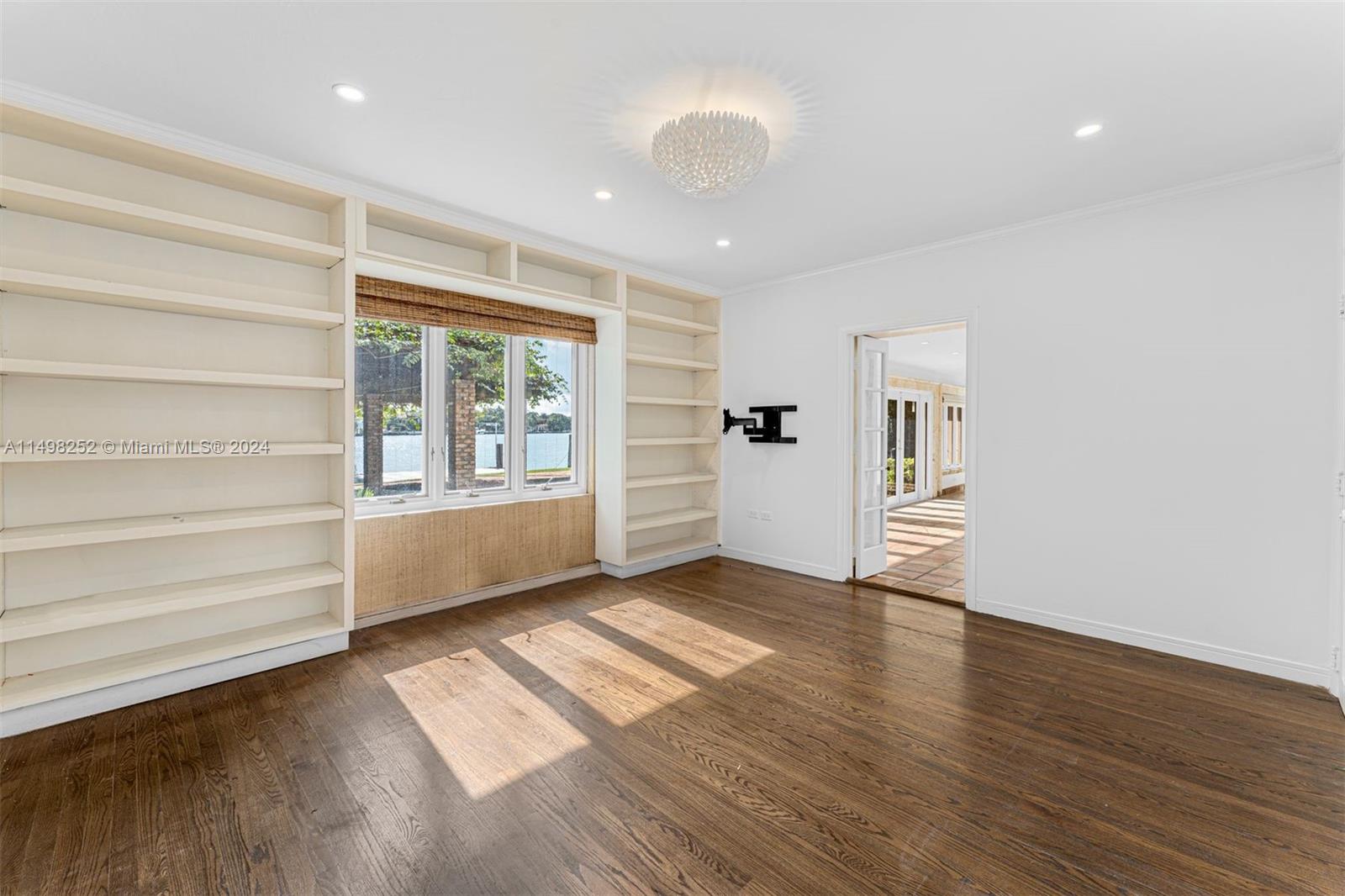 12 Lagorce Circle Miami Beach, FL 33141 - Photo 19 of 23 a view of an empty room with a window and wooden floor