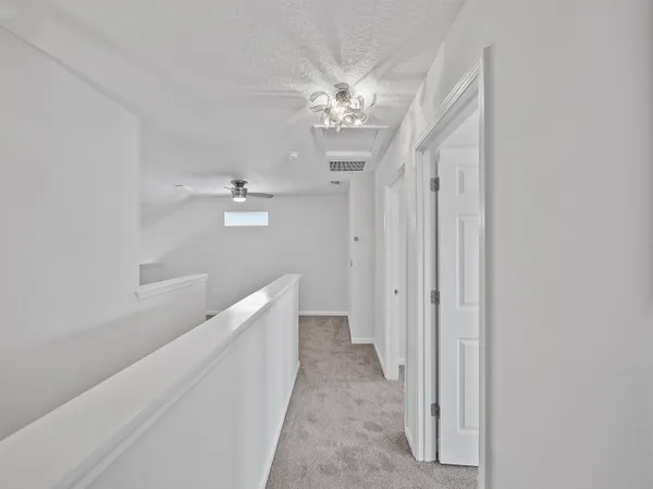 a hallway with windows and a chandelier