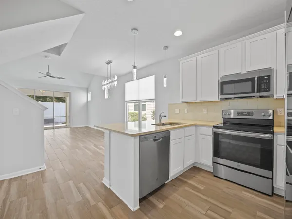 a kitchen with stainless steel appliances granite countertop a stove a sink and a microwave