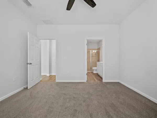 a view of an empty room with chandelier fan