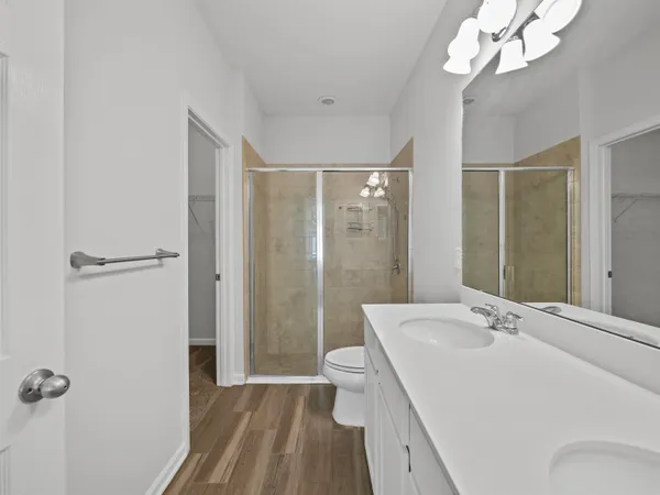 a bathroom with a sink a toilet a mirror and shower