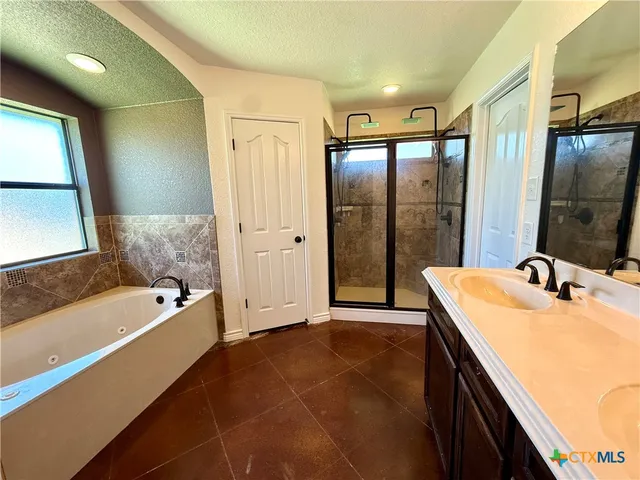 a bathroom with a tub sink and mirror