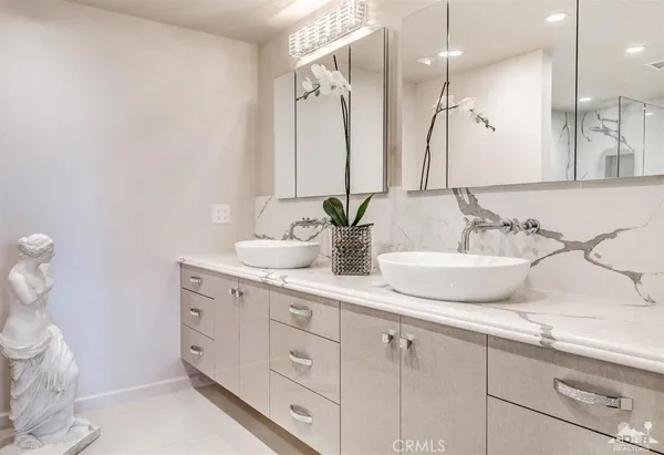a bathroom with a double vanity sink mirror and shower