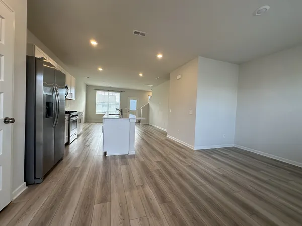 a view of a large kitchen with wooden floor and a window