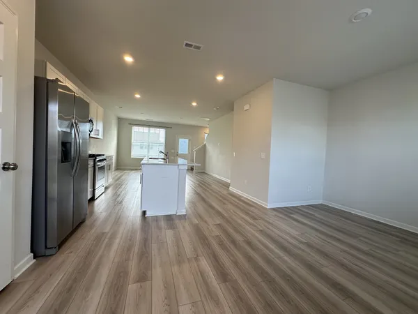 a view of a big room with wooden floor and windows