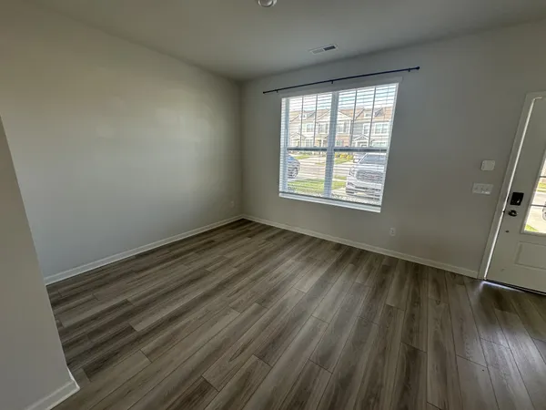 a view of a room with wooden floor and window