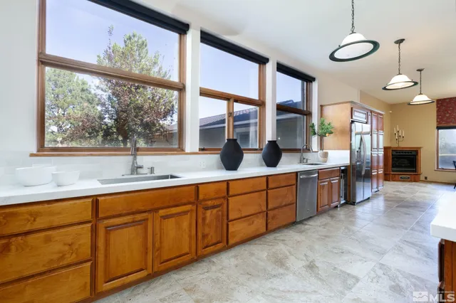 a large kitchen with kitchen island granite countertop a large window and a sink