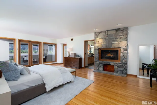 a spacious bedroom with a bed and wooden floor