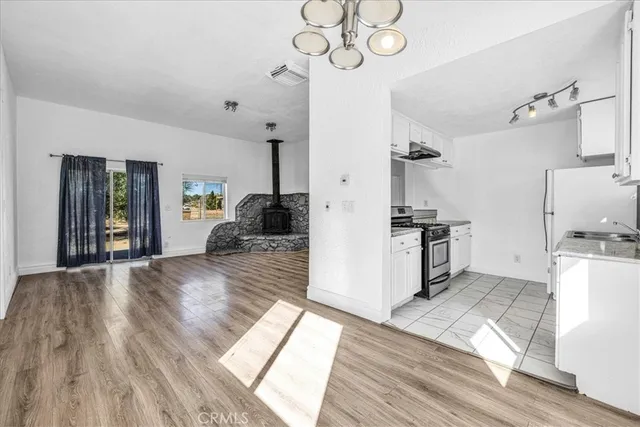a kitchen with granite countertop a sink a stove and refrigerator
