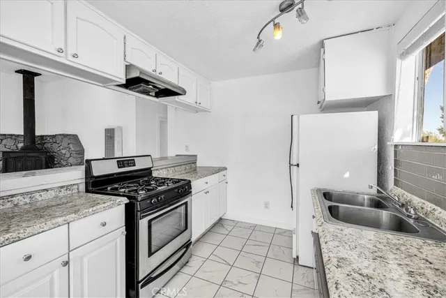 a kitchen with a stove a sink and a refrigerator