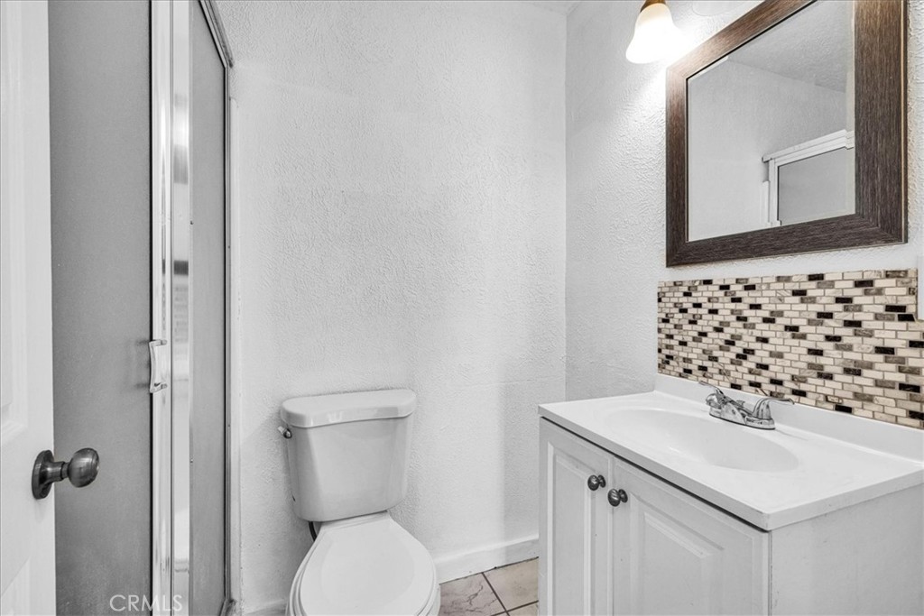 6686 Mojave Avenue Twentynine Palms, CA 92277 - Photo 26 of 41 a bathroom with a sink a toilet and mirror
