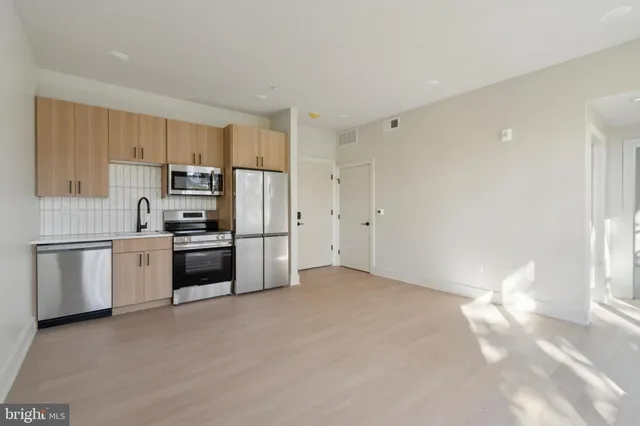 a kitchen with granite countertop white cabinets and stainless steel appliances