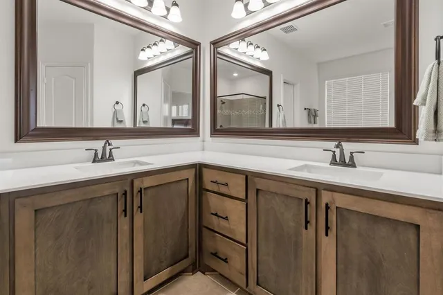a spacious bathroom with a sink a mirror and shower