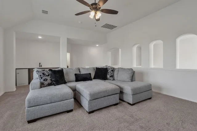 a living room with furniture and a large window with a chandelier