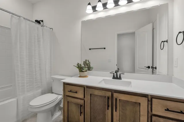 an empty room with a chandelier fan and windows