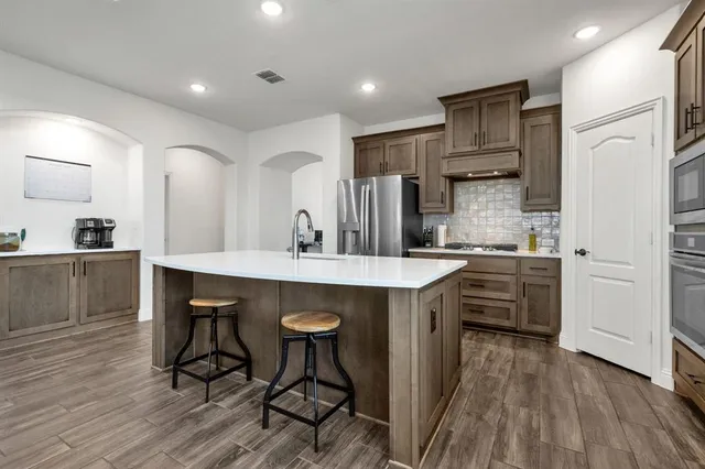 a kitchen with stainless steel appliances a sink stove and refrigerator
