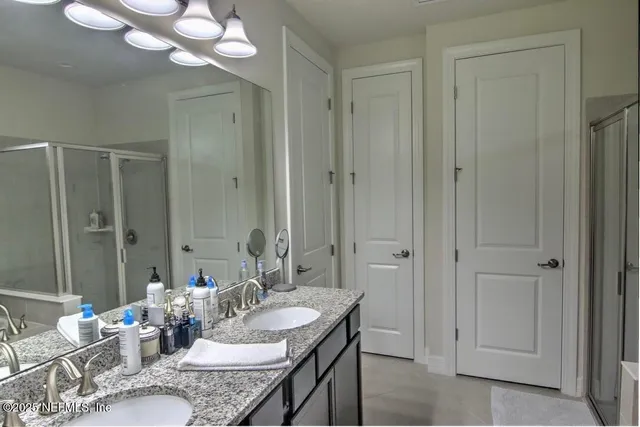 a bedroom with a bed chandelier and a window