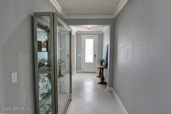 a view of a hallway with wooden floor and a bathroom