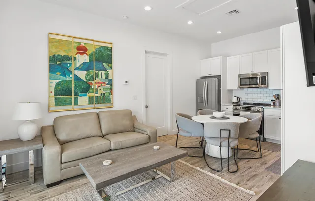 a living room with furniture a large window and a dining table