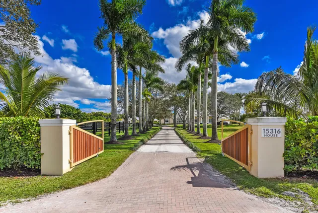 front view of a house with a yard and palm trees
