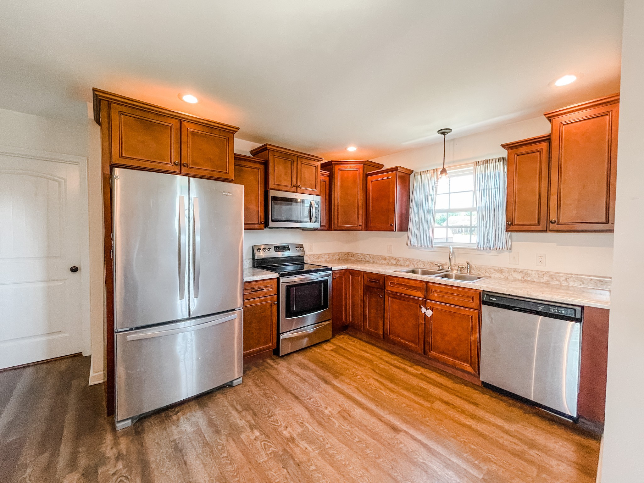 224 Shaub Road Portland, TN 37148 - Photo 7 of 23 a kitchen with granite countertop stainless steel appliances a refrigerator a stove top oven and wooden floors