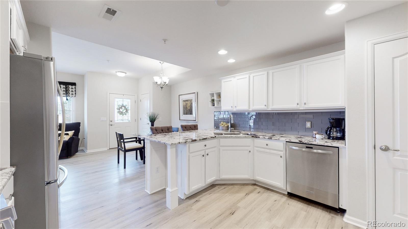 11331 Xavier Drive, Unit 103 Westminster, CO 80031 - Photo 16 of 30 a kitchen with a sink cabinets and wooden floor