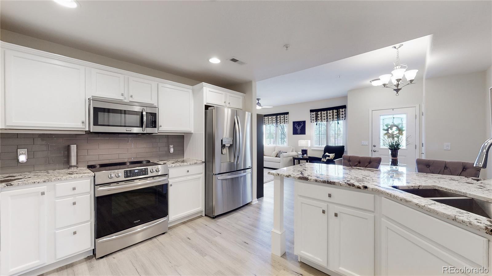 11331 Xavier Drive, Unit 103 Westminster, CO 80031 - Photo 3 of 30 a kitchen with a sink stove and refrigerator