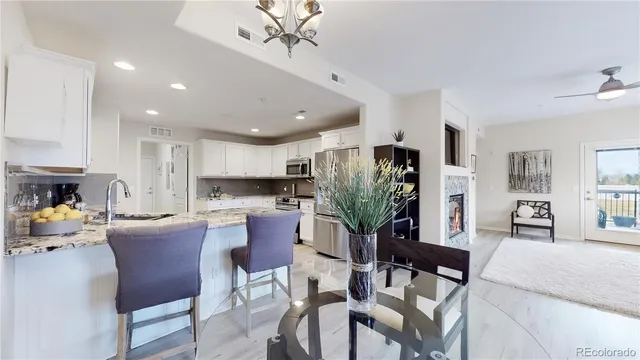 a living room with stainless steel appliances furniture a dining table and kitchen view