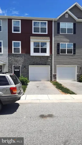 a front view of a house with car parked