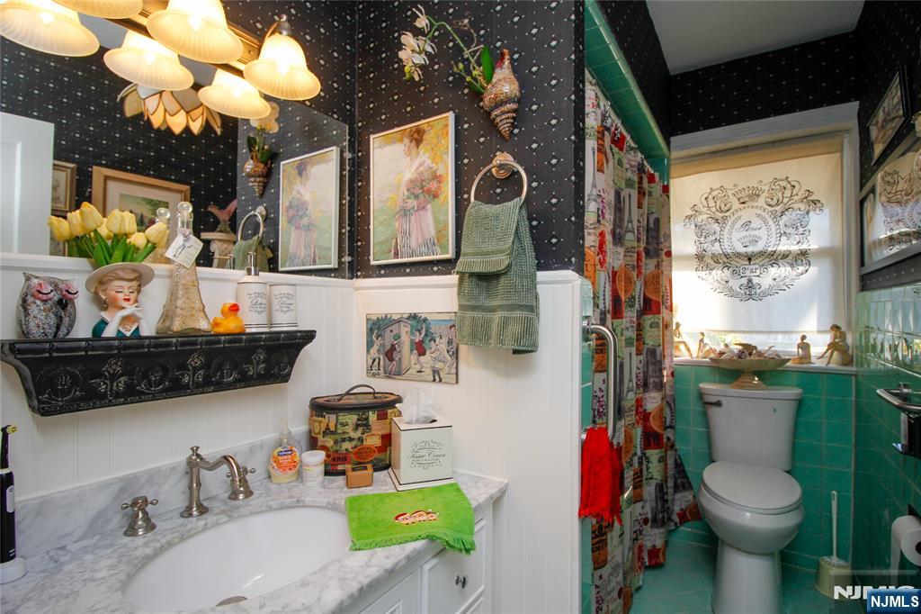 301 3rd Street Clifton, NJ 07011 - Photo 2 of 28 a bathroom with a toilet sink and mirror