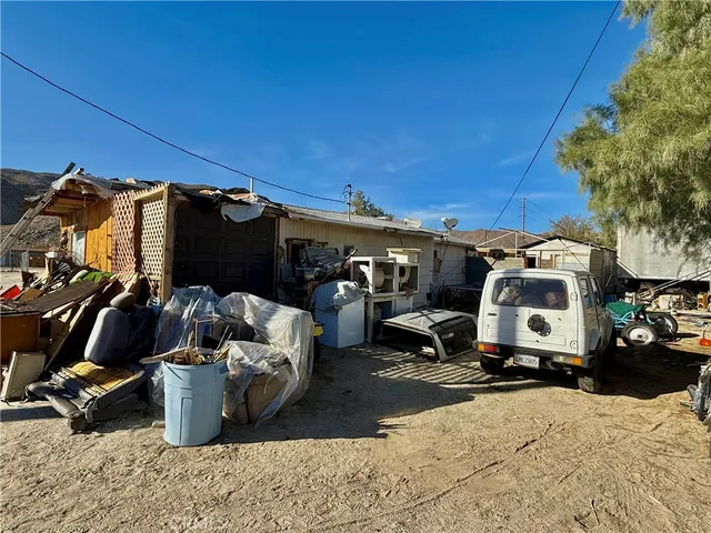 a view of a patio with table and chairs and a barbeque