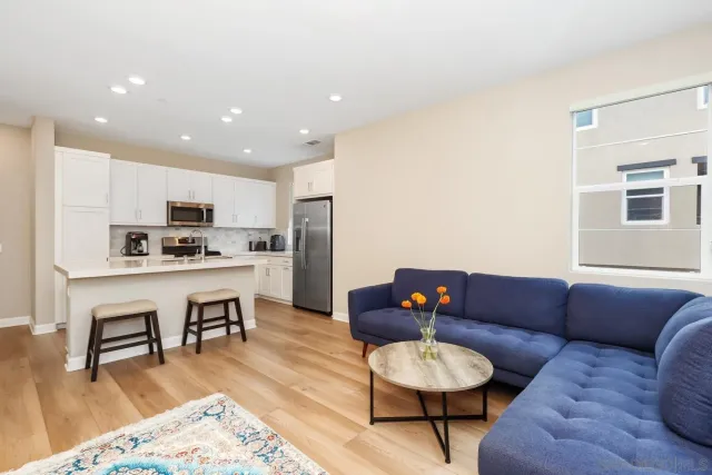 a living room with furniture and a dining table with kitchen view