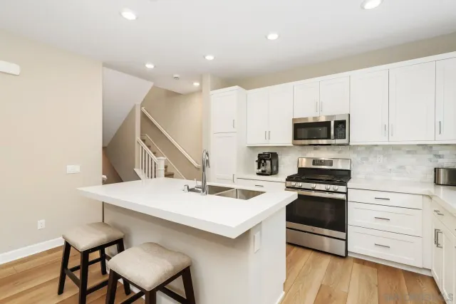 a kitchen with a stove a sink and a refrigerator
