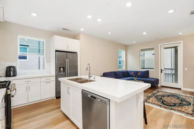 a kitchen that has a sink a stove and chairs