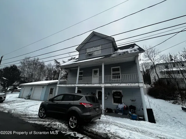 a backyard of a house with lots of trees and wooden fence
