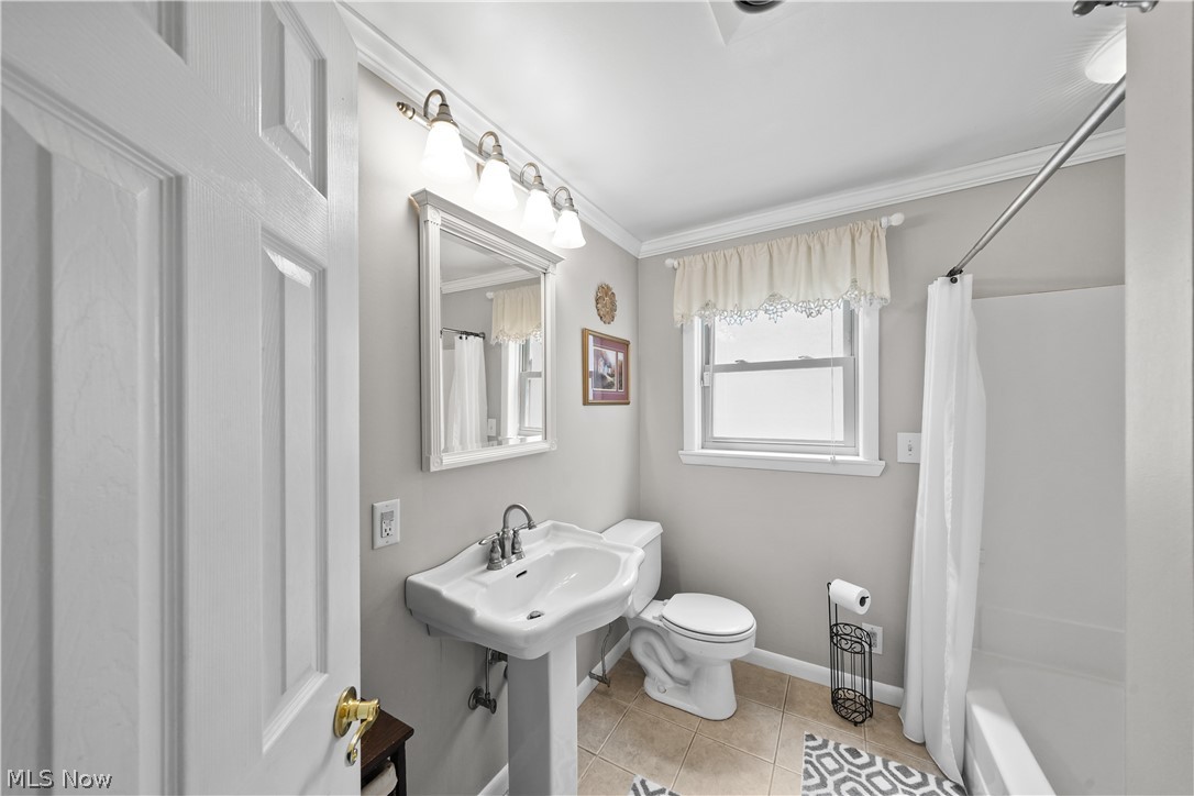 11247 Prospect Road Strongsville, OH 44149 - Photo 40 of 49 Bathroom featuring tile floors, ornamental molding, shower / tub combo with curtain, and toilet