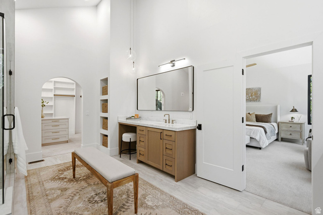 3027 Homestead Road Park City, UT 84098 - Photo 27 of 62 Spacious bathroom featuring a single vanity with wood cabinetry and a light-toned countertop, a large framed mirror, and integrated shelving niches
