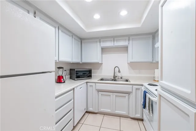 a kitchen with a sink cabinets and white appliances
