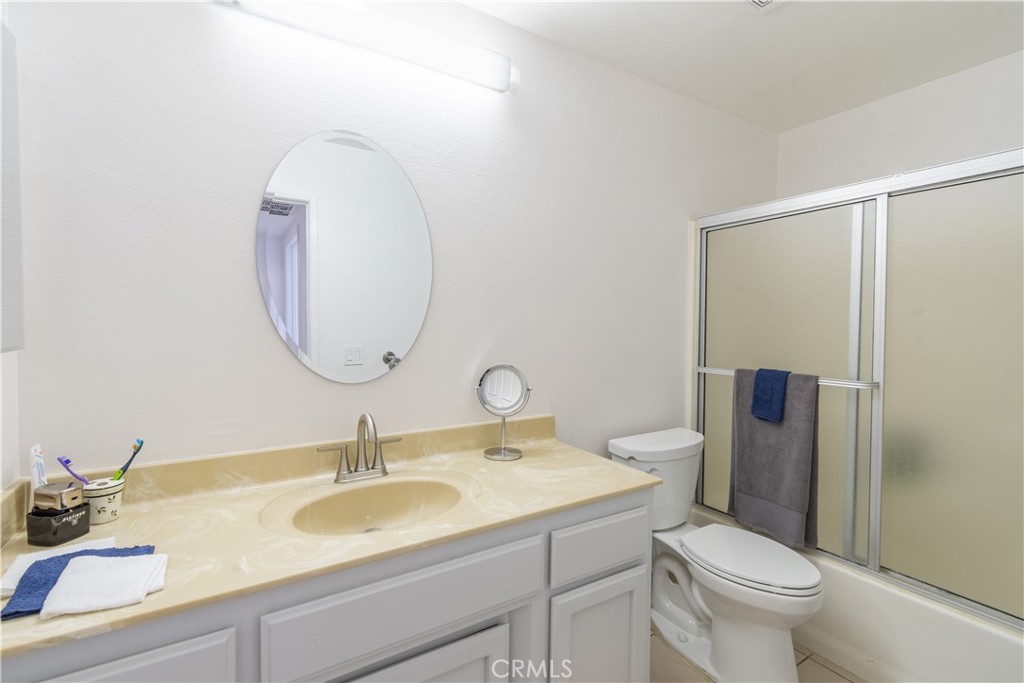 3121 Spring Street, Unit 106 Paso Robles, CA 93446 - Photo 7 of 10 a bathroom with a toilet sink and mirror