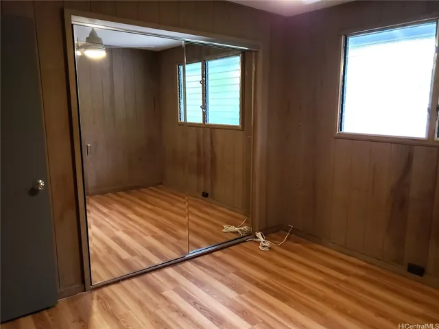 a view of empty room with window and wooden floor