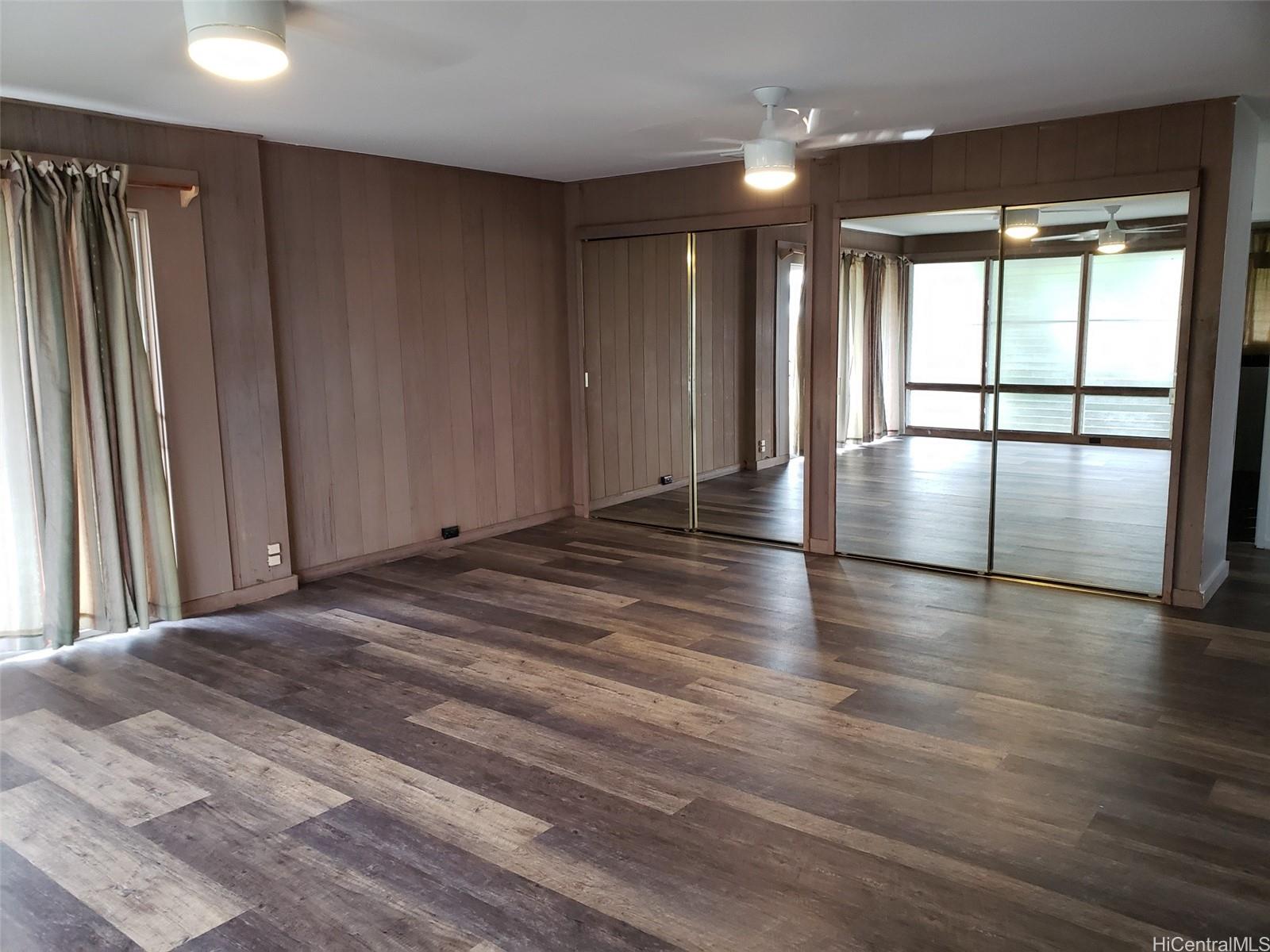 3403 Ala Ilima Street Honolulu, HI 96818 - Photo 10 of 23 an empty room with wooden floor and windows with curtains