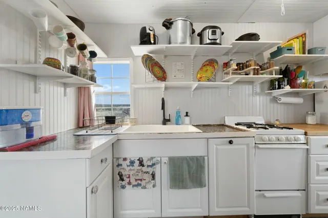 a kitchen with stainless steel appliances granite countertop a sink and a stove
