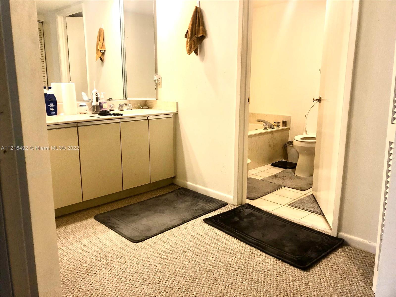 520 Brickell Key Drive, Unit A1102 Miami, FL 33131 - Photo 11 of 20 a bathroom with a sink a toilet and a mirror