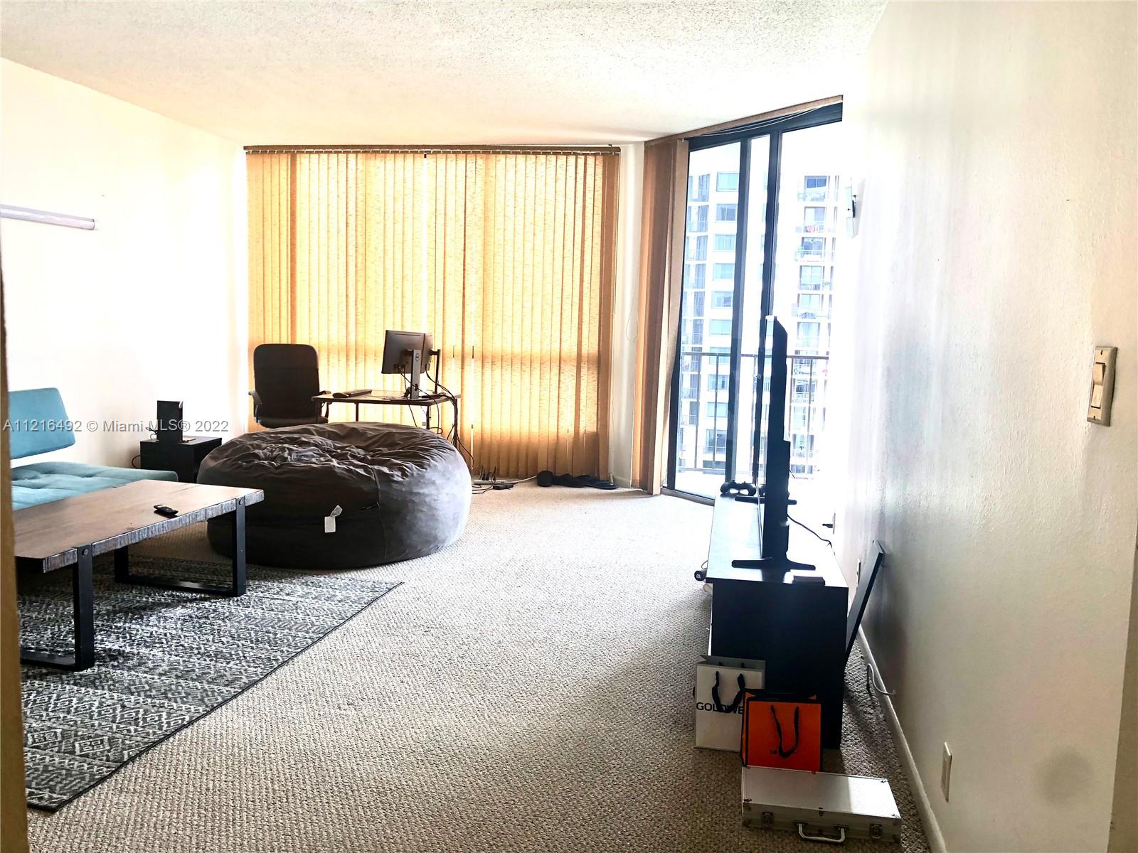 520 Brickell Key Drive, Unit A1102 Miami, FL 33131 - Photo 5 of 20 a living room with furniture and large windows