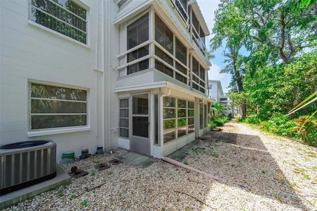 a view of a patio with table and chairs potted plants and large tree